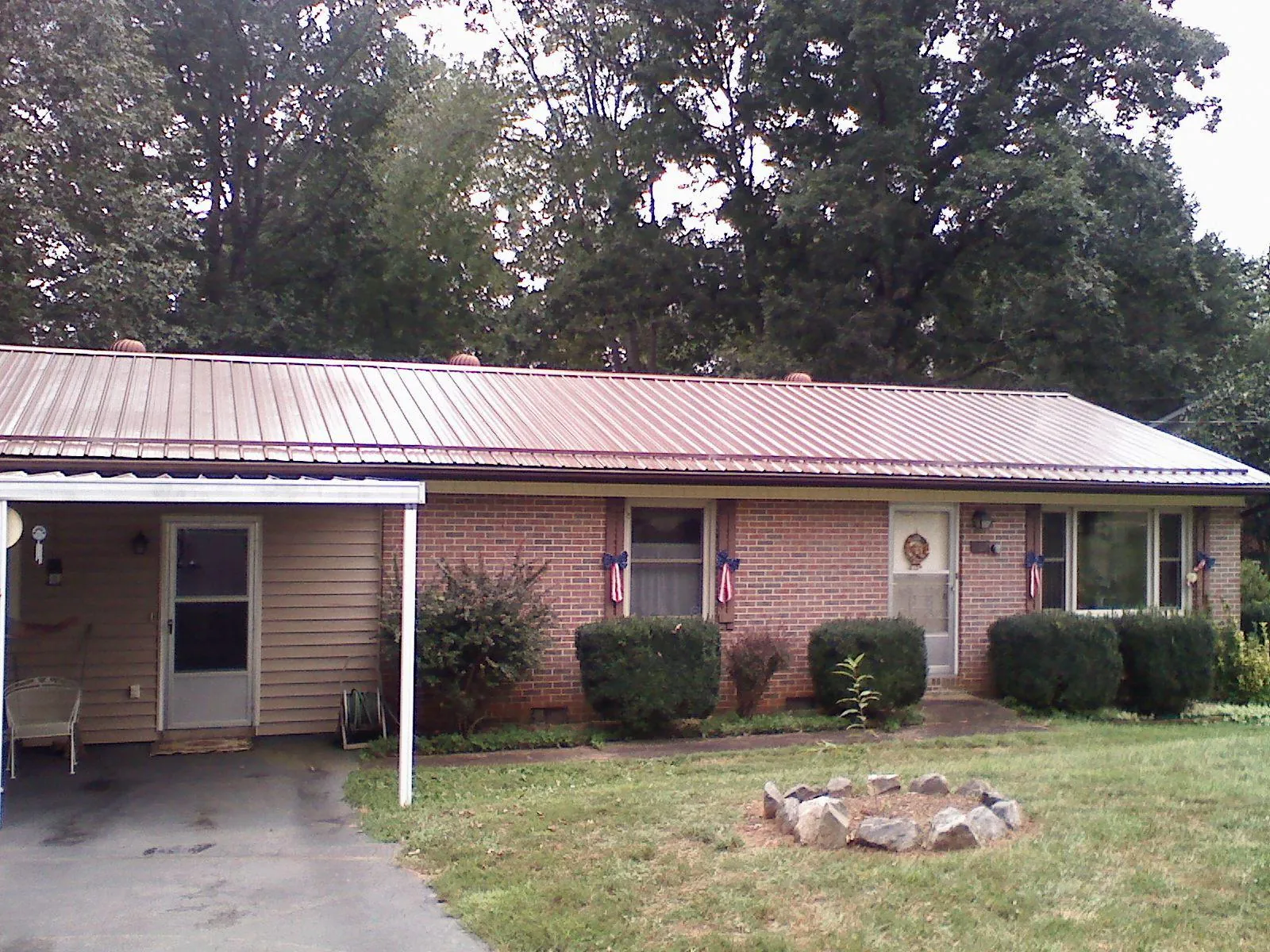 Bronze metal roof and carport on a brick ranch home — Roof Repair work by our crew in Gretna